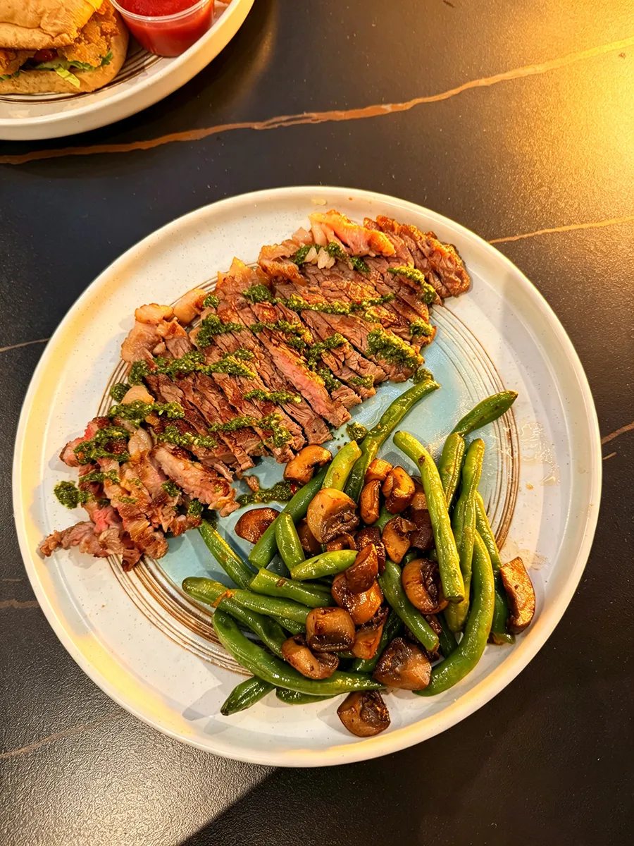 Sliced steak with green beans, mushrooms and herb sauce at 21 Raw Bar Taphouse & Grill, a Seafood Restaurant in Greenville