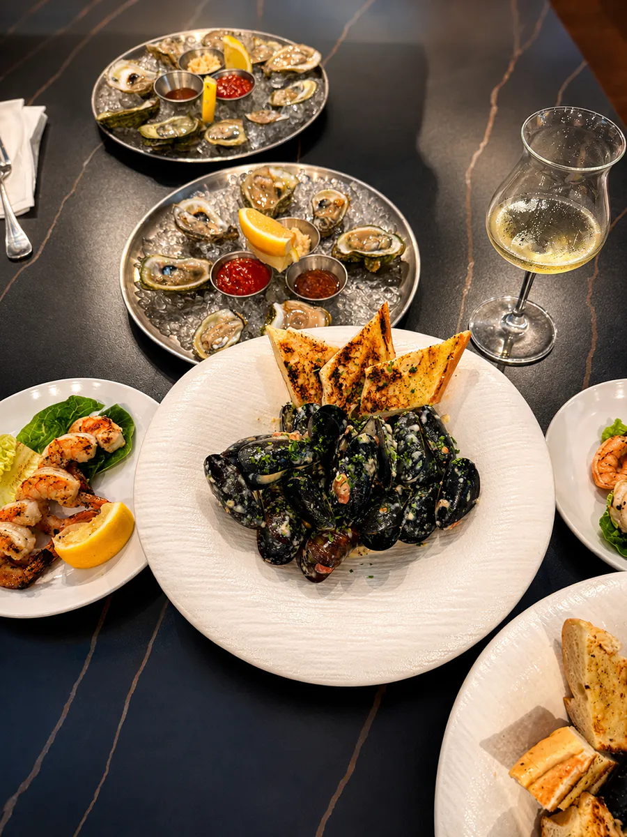 Seafood feast with mussels, oysters, grilled shrimp and a glass of wine at 21 Raw Bar Taphouse & Grill, a Seafood Restaurant in Greenville