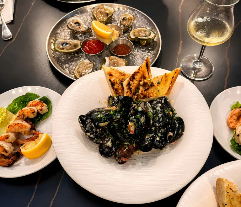 Seafood feast with mussels, oysters, grilled shrimp and a glass of wine at 21 Raw Bar Taphouse & Grill, a Seafood Restaurant in Greenville